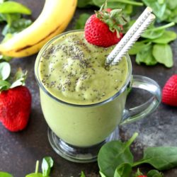 Green Strawberry Smoothie in a clear mug with straws