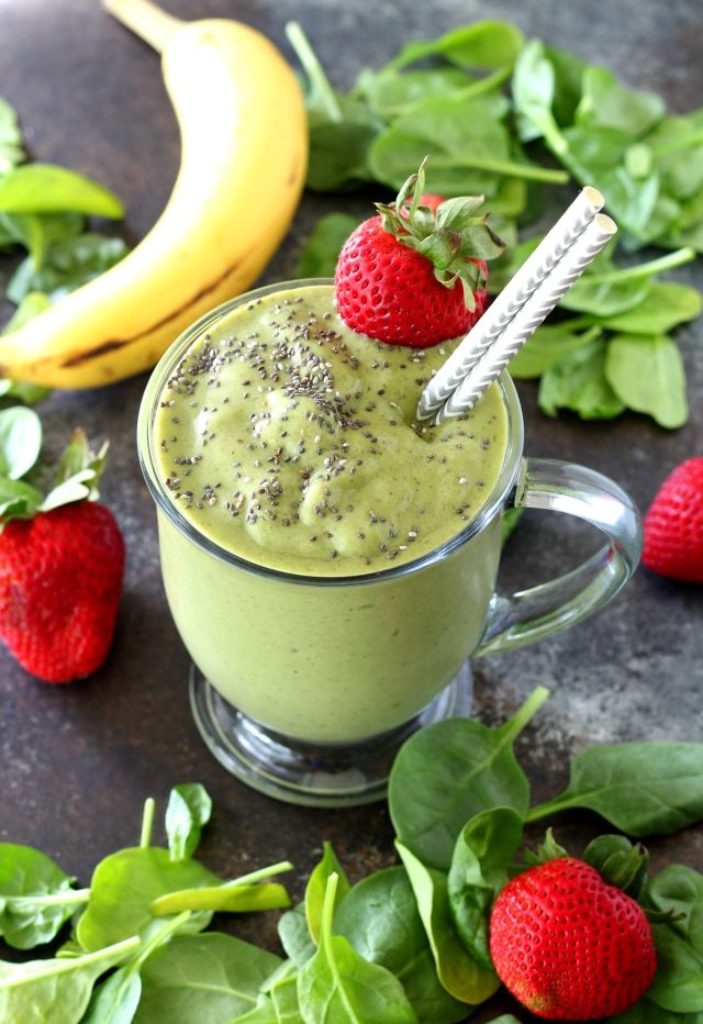 Green Strawberry Smoothie in a clear mug with straws