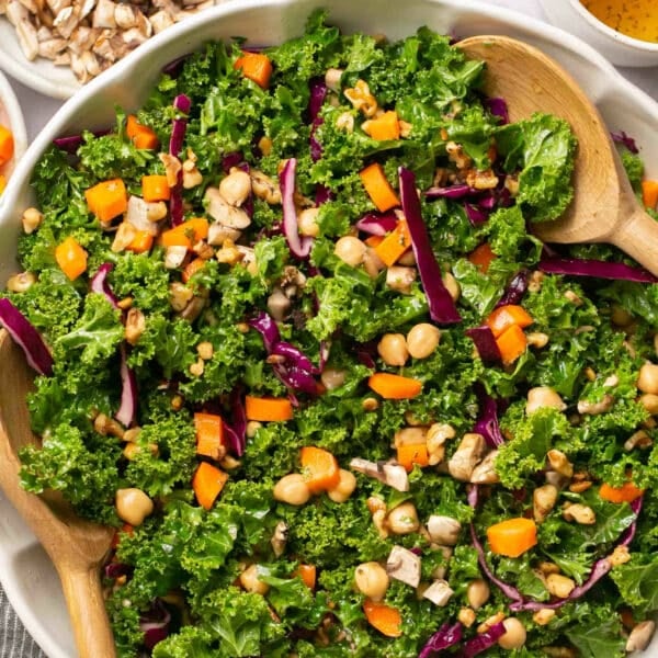 Fresh green salad served with large wooden spoons.