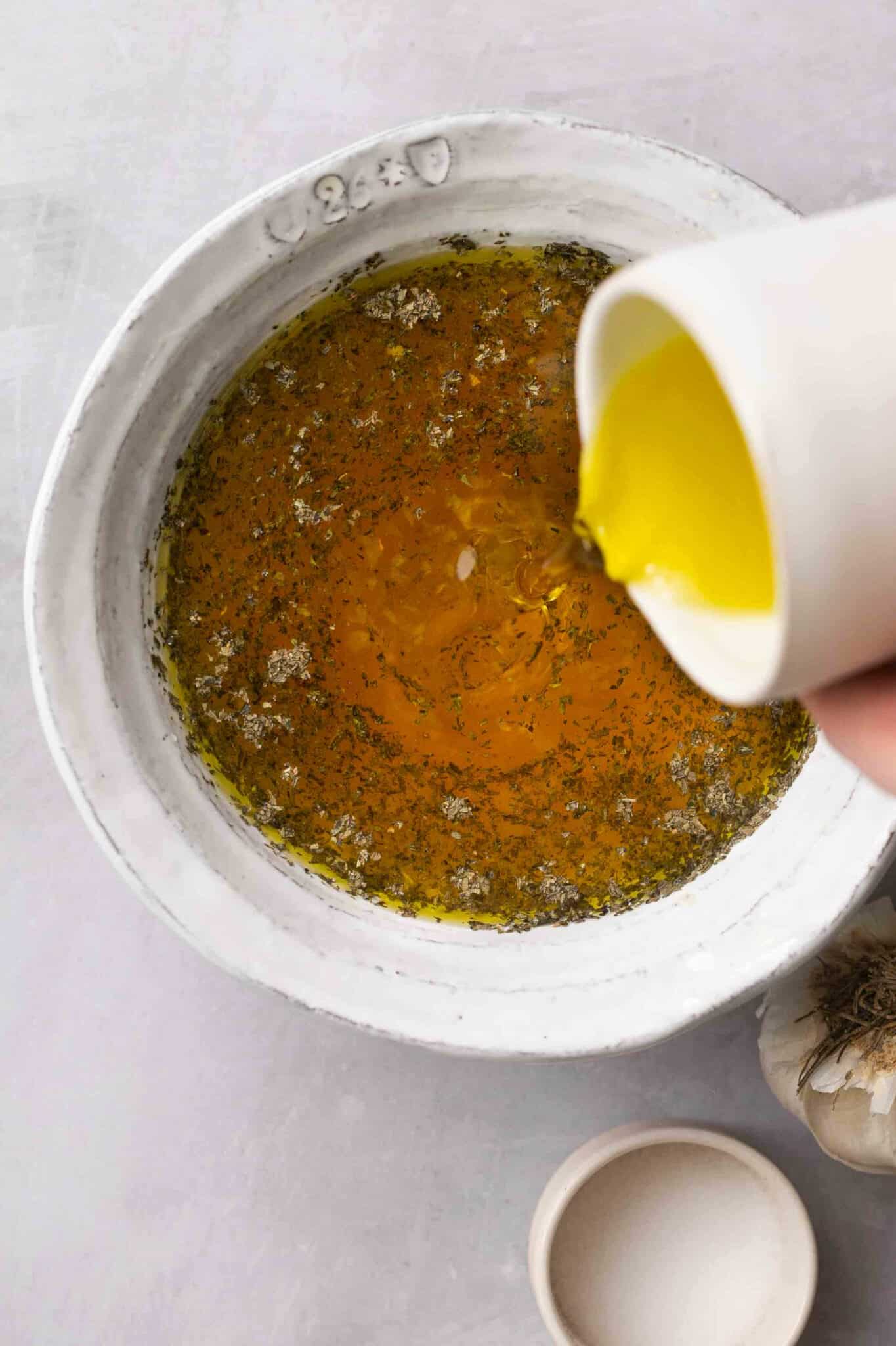 Pouring oil into bowl to make dressing.