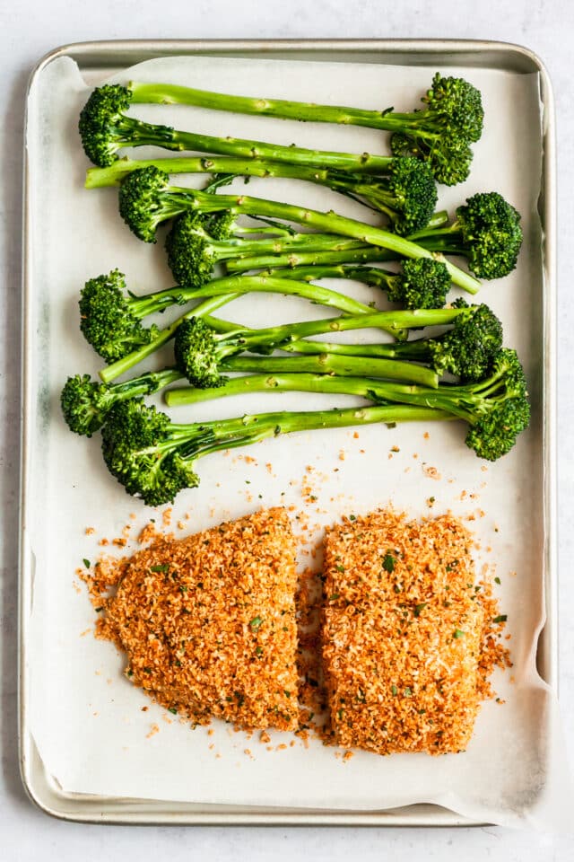 Parmesan Crusted Cod and broccoli on a baking sheet ready to be cooked