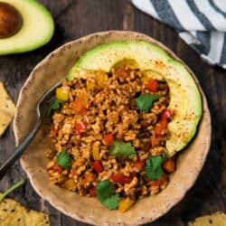 easy unstuffed bell pepper skillet in a bowl topped with avocado slices and fresh cilantro