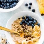 Best Banana Bread Oatmeal served in a white bowl and topped with blueberries