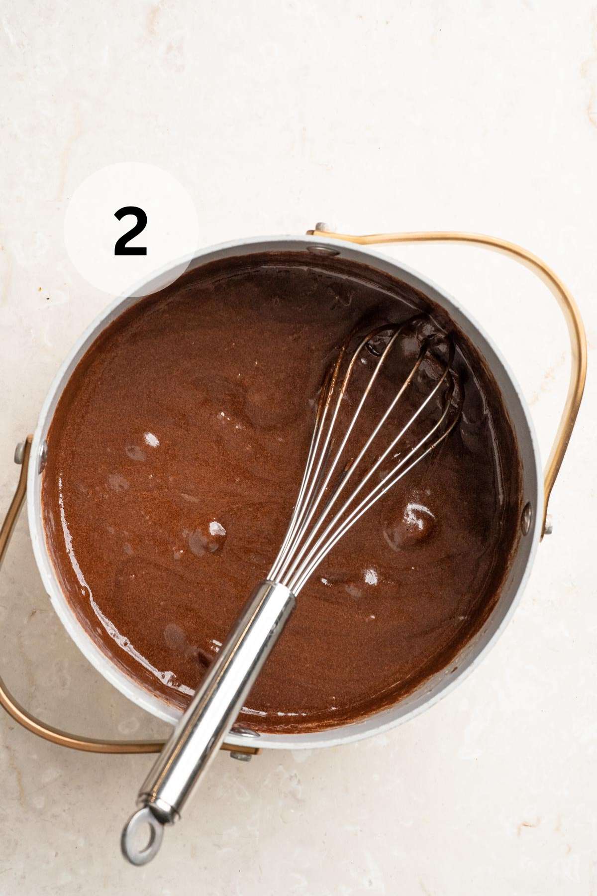 Whisking in the sugar and vanilla extract to melted chocolate.