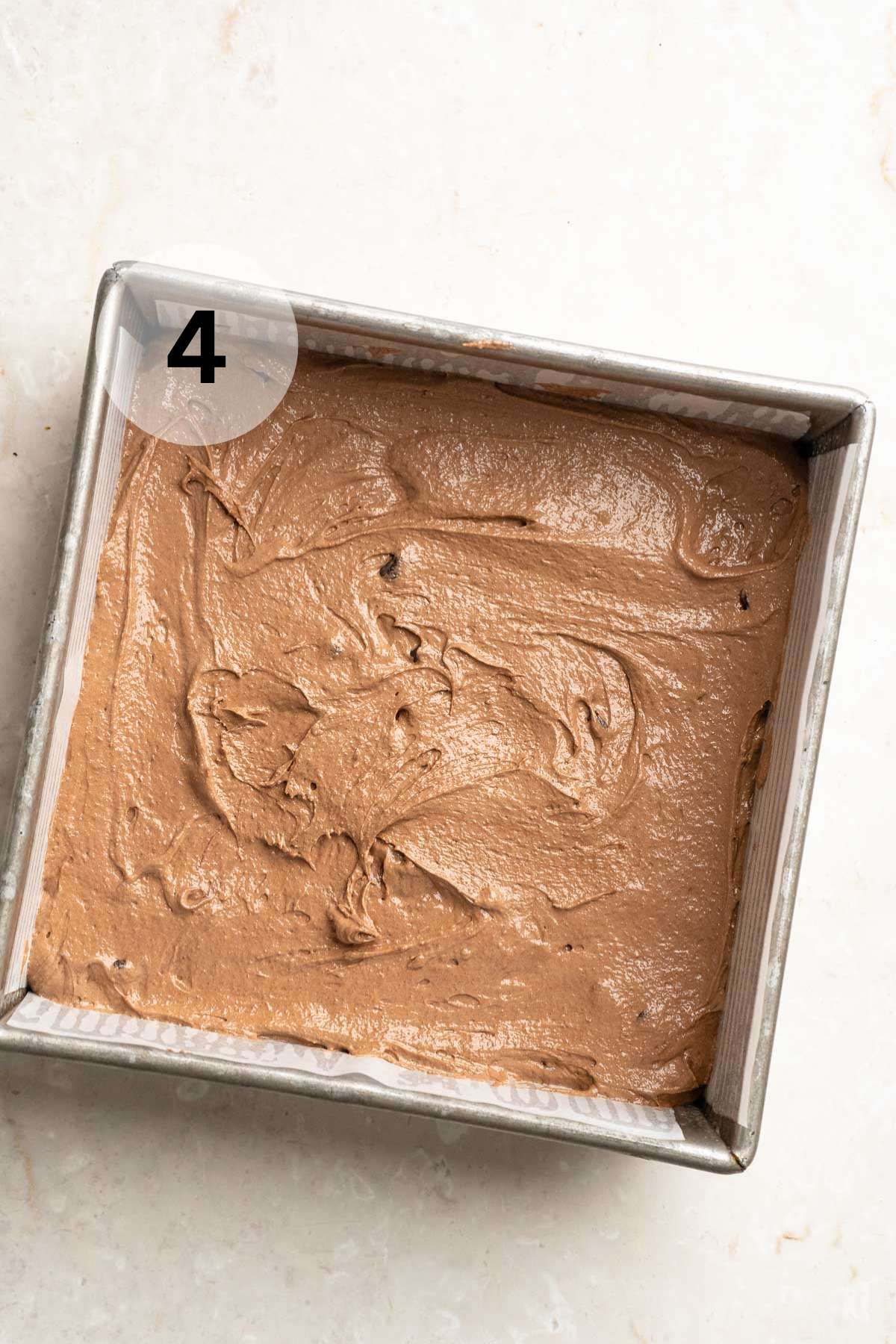 Brownie batter in a square pan.