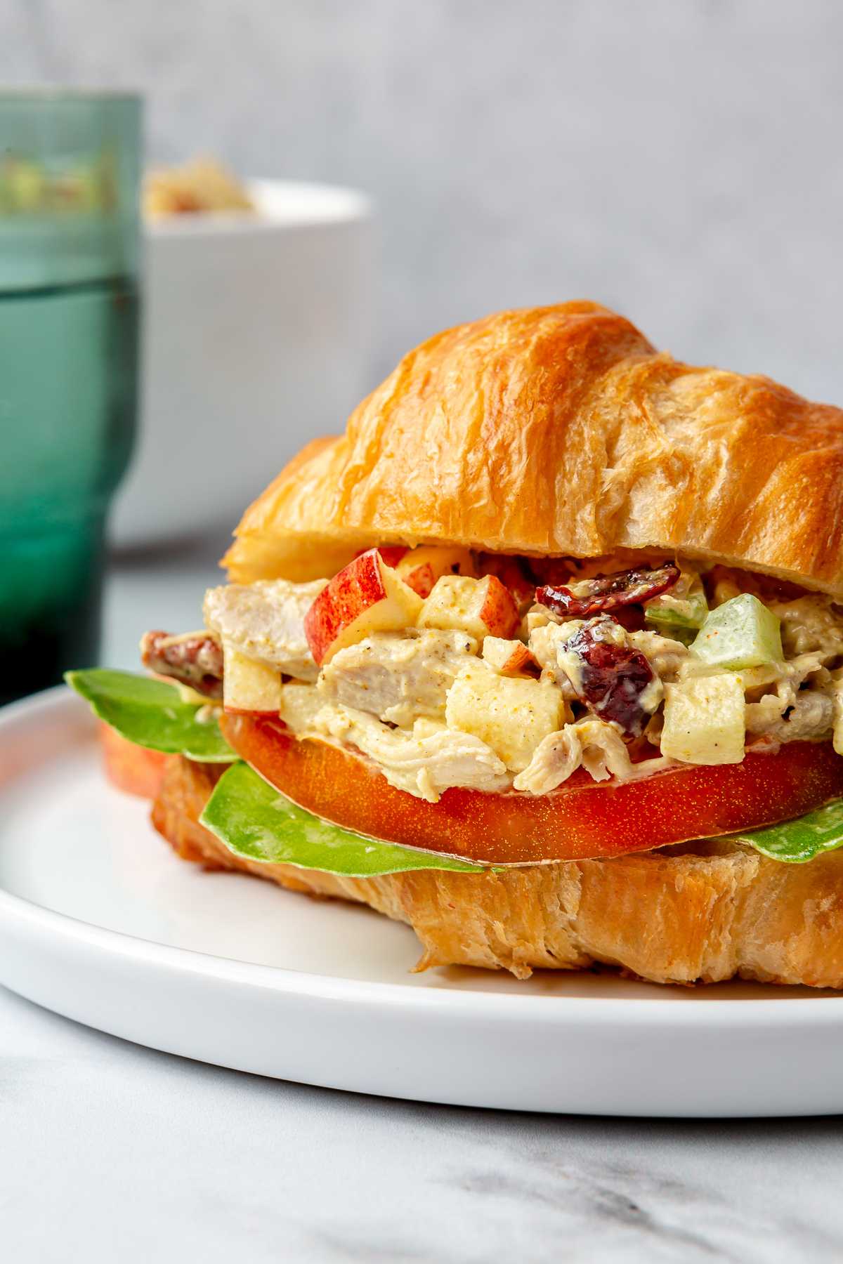 Curried chicken salad served with lettuce and tomato on a croissant. 
