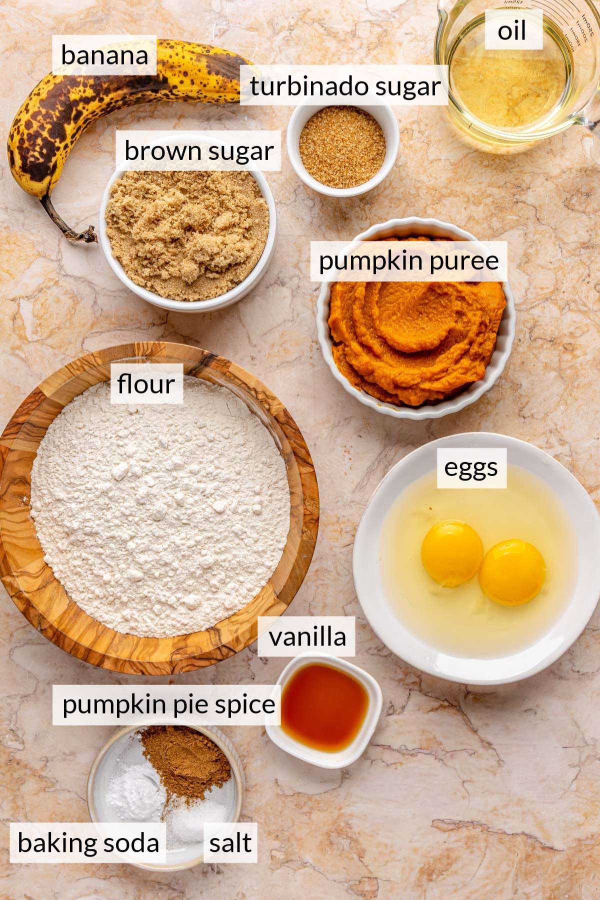 Small bowls with flour, sugar, vanilla, pumpkin and eggs.