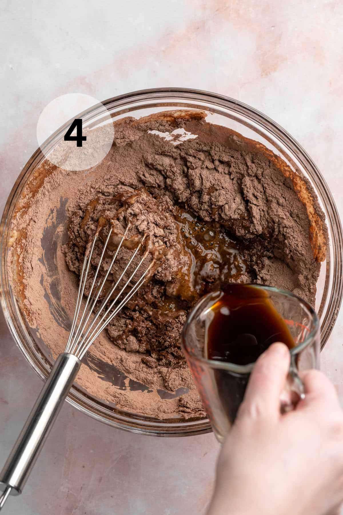 Pouring coffee into chocolate cupcake batter.