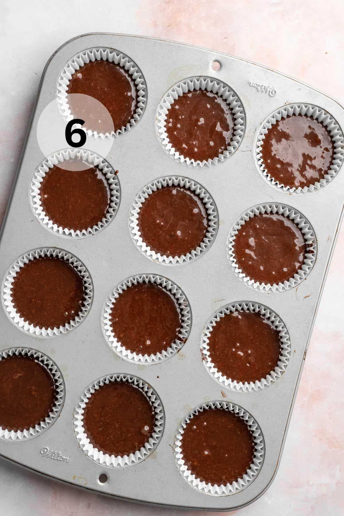 Chocolate batter in a muffin pan.