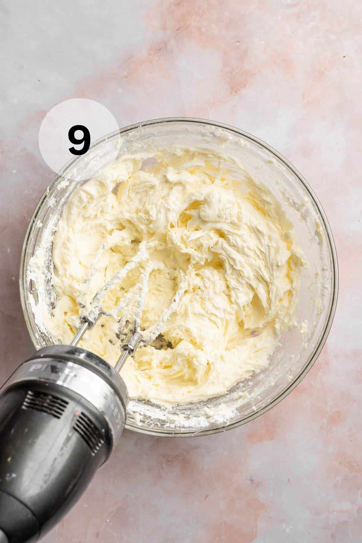 Beating powder sugar with butter in a large bowl.