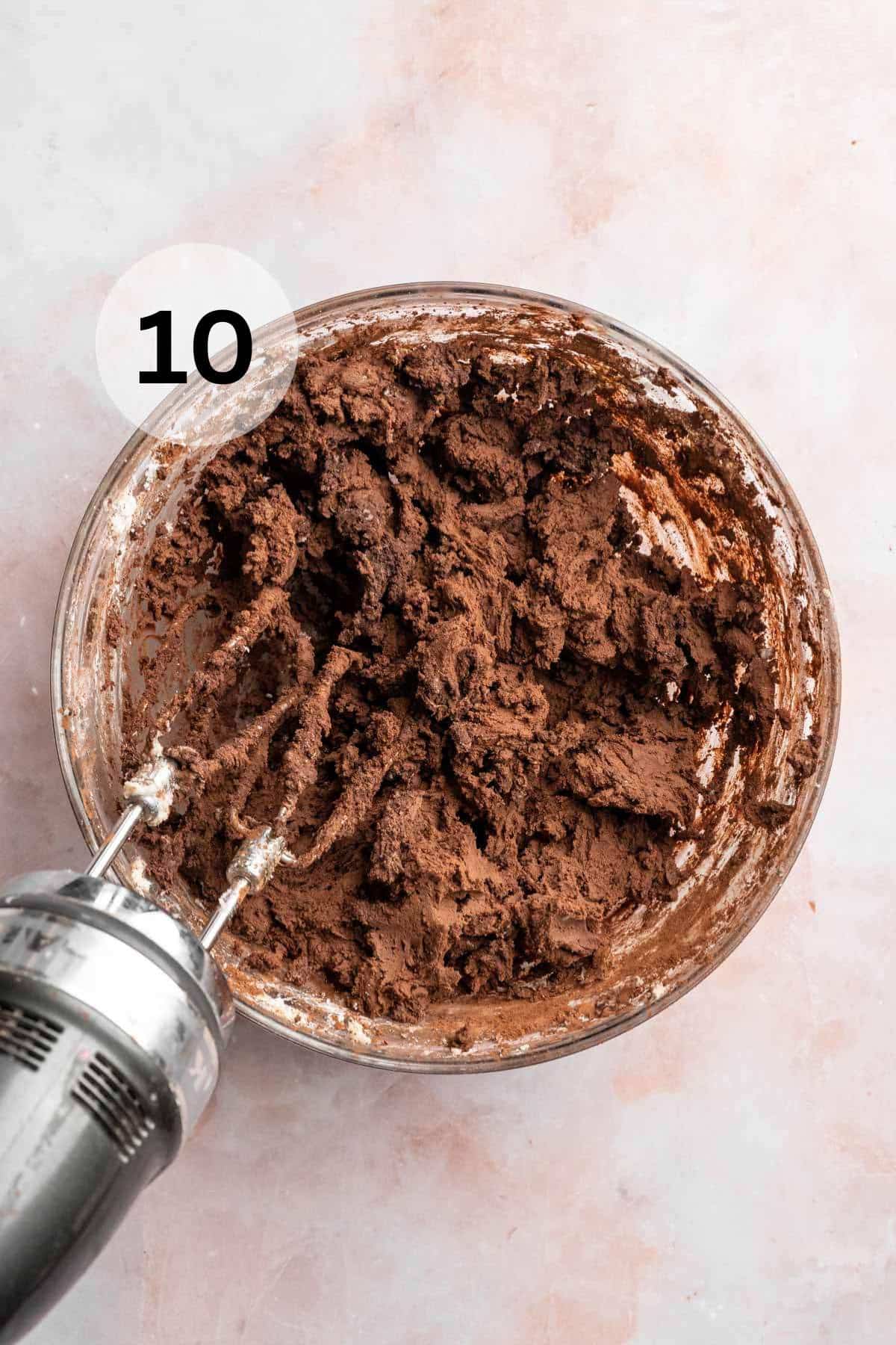 Using a mixer to mix chocolate frosting.