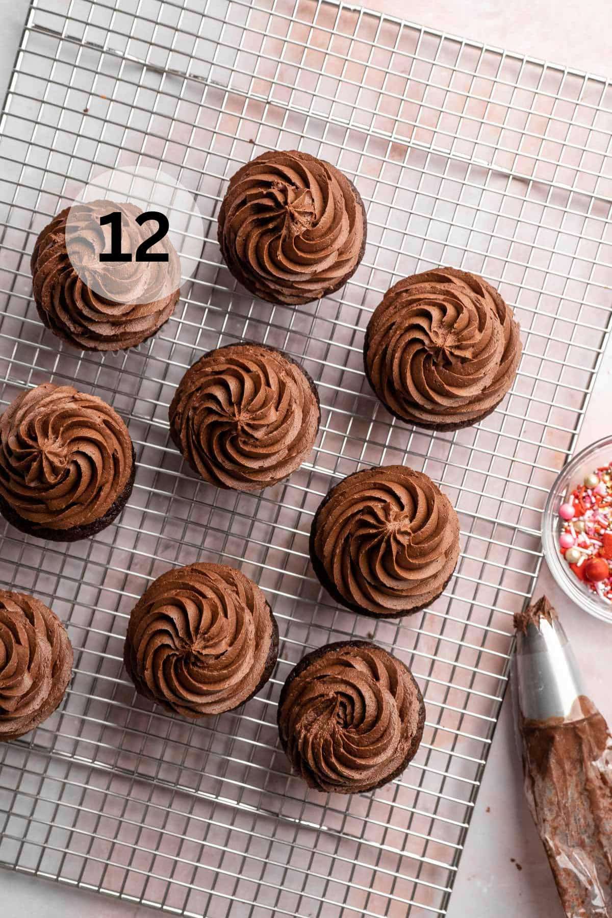 Frosting chocolate cupcakes on a wire rack.
