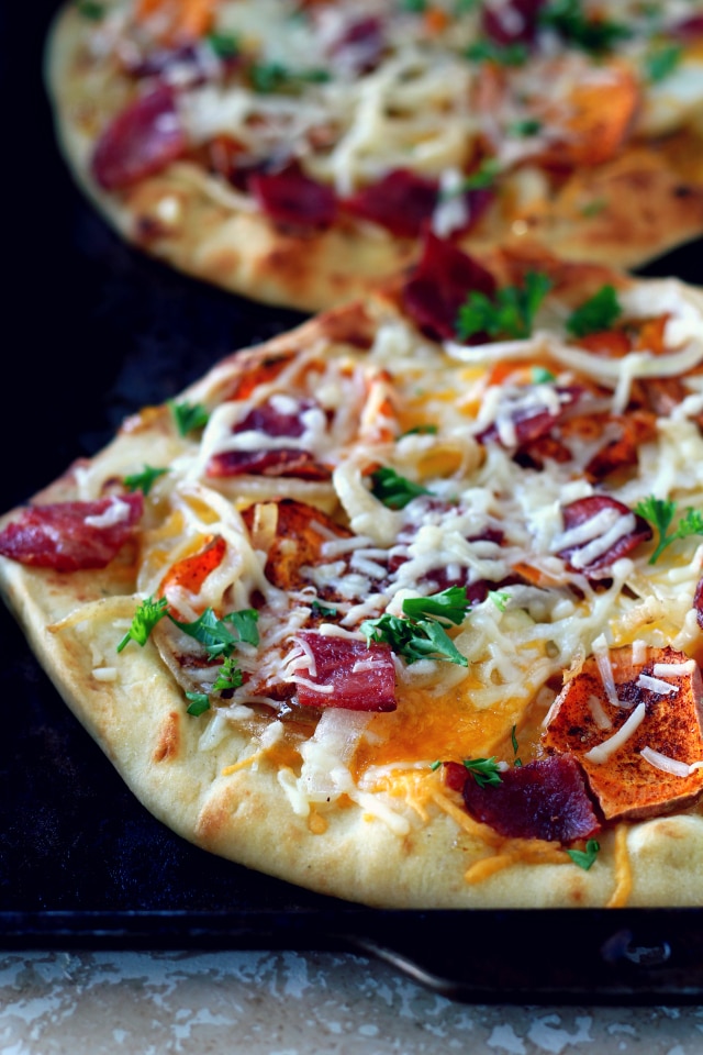 This rustic fall harvest naan pizza recipe features seasonal ingredients including sweet potato, apple, crisp bacon and caramelized onion. The perfect dinner for a cozy night by the fire!