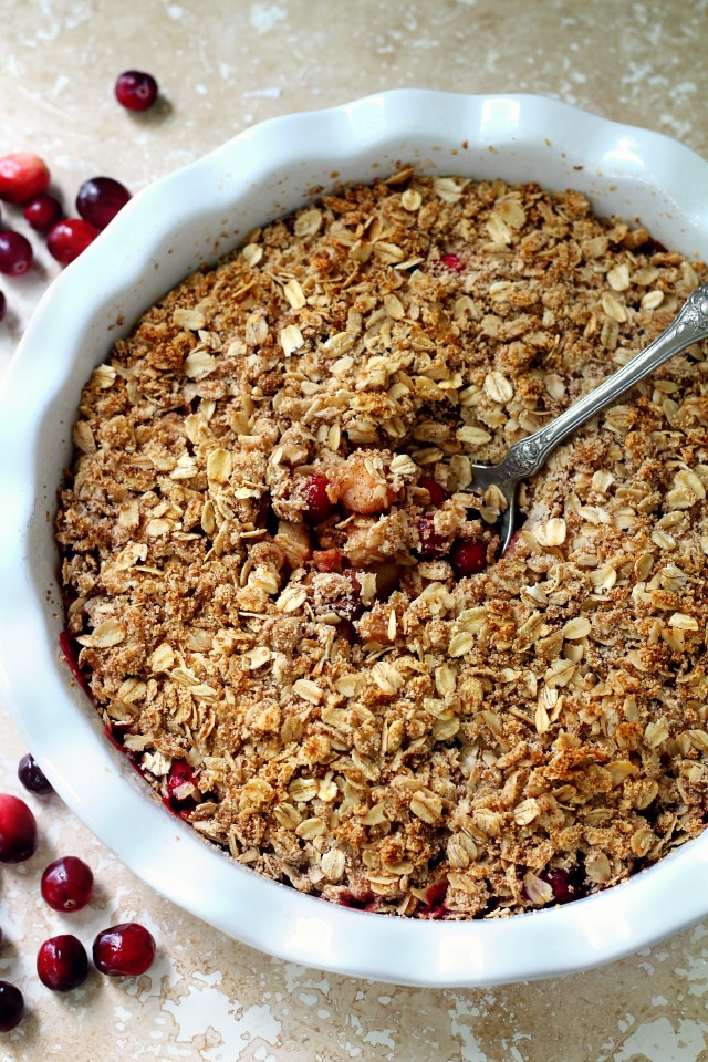 Cranberry Pear Crisp in a white pie plate with a spoon in the middle