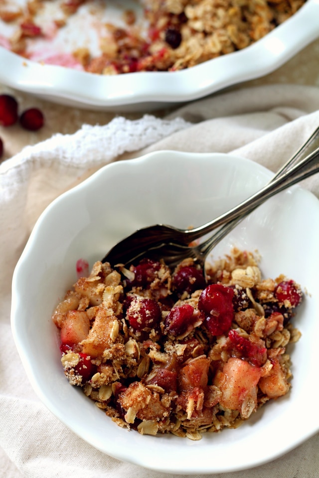 Cranberry Pear Crisp served in a white bowl with a spoon 