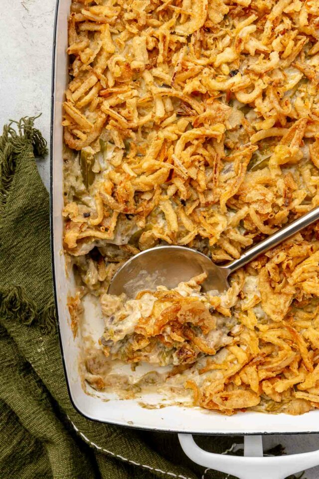 Using a serving spoon to dish out green bean casserole.