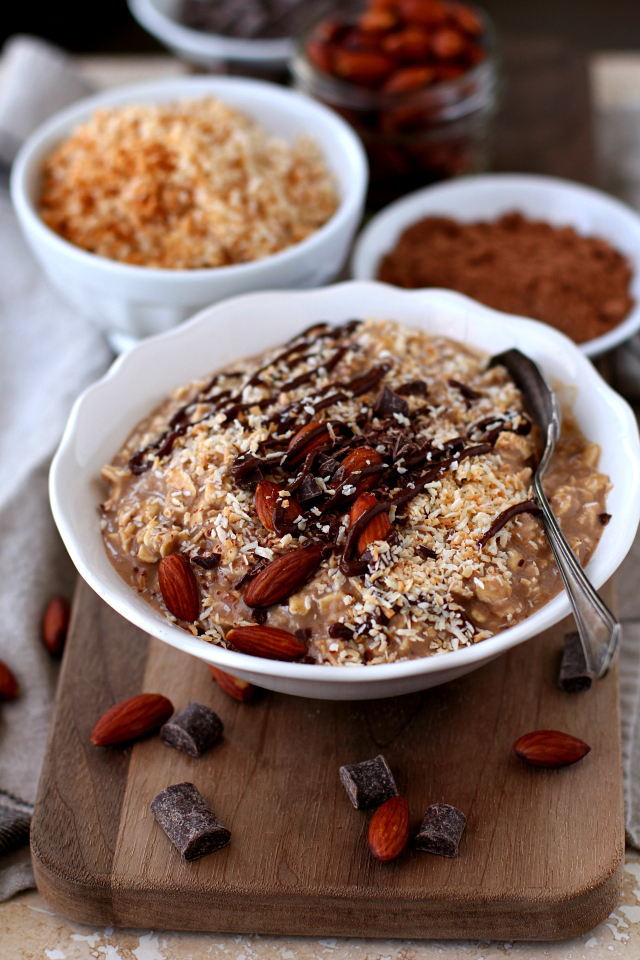 Almond Joy Protein Overnight Oatmeal served in a white bowl with a silver spoon