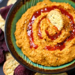 Carrot Ginger Hummus with a cracker on top