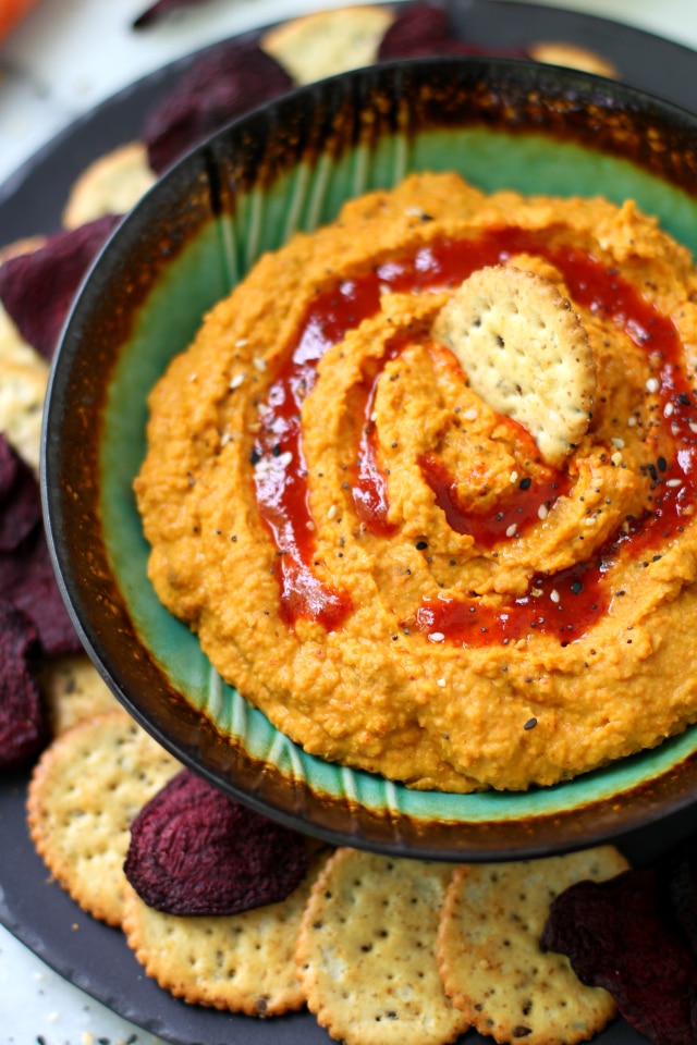 Carrot Ginger Hummus with a cracker on top