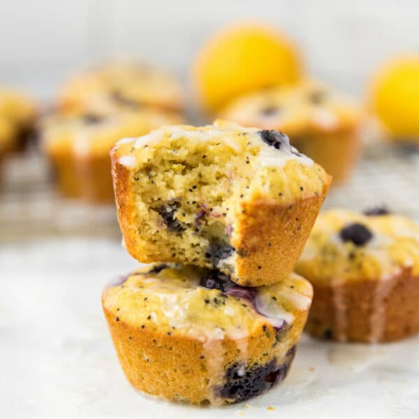 two lemon blueberry muffins with icing stacked