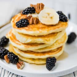 fluffy pancakes stacked on a white plate