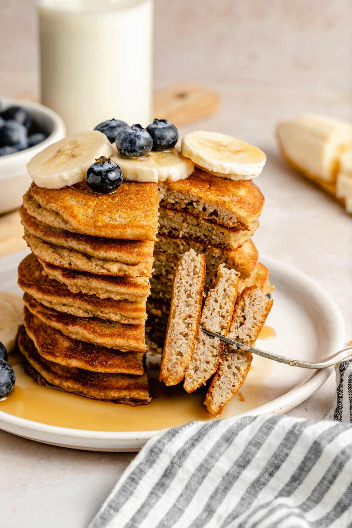 Taking a forkful of pancakes out of a stack.