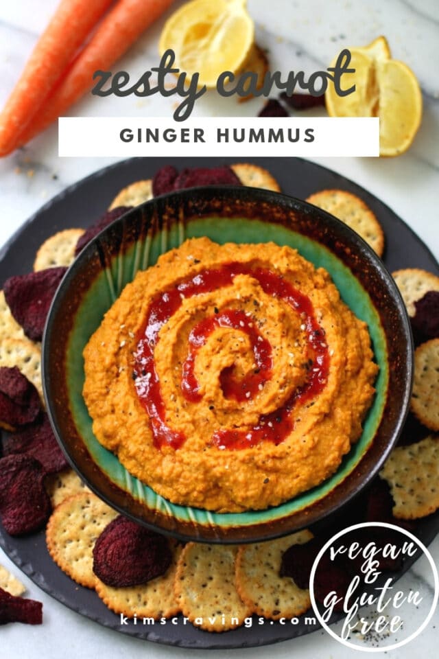 carrot hummus with a swirl of Sriracha sauce served with crackers around the dish