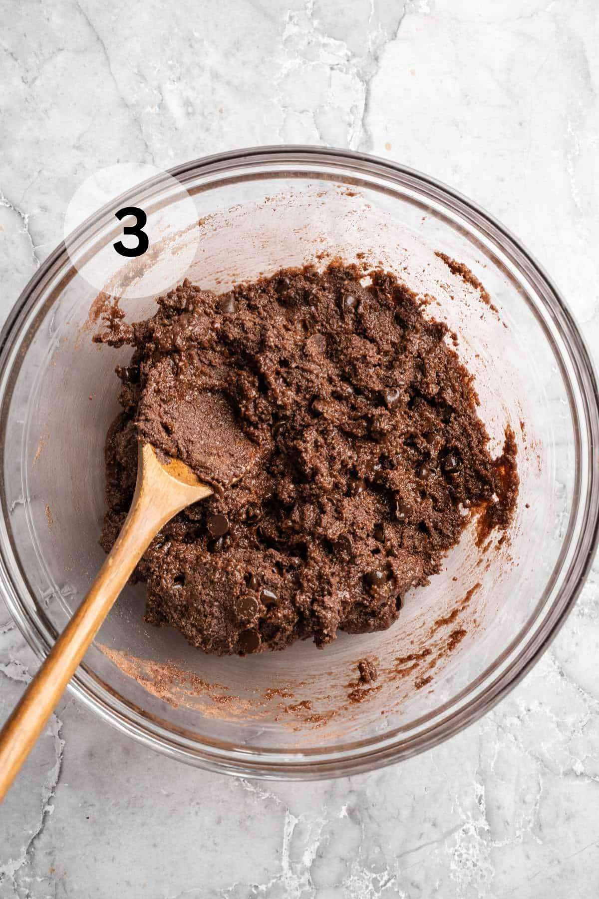Using a wooden spoon to stir brownie batter.