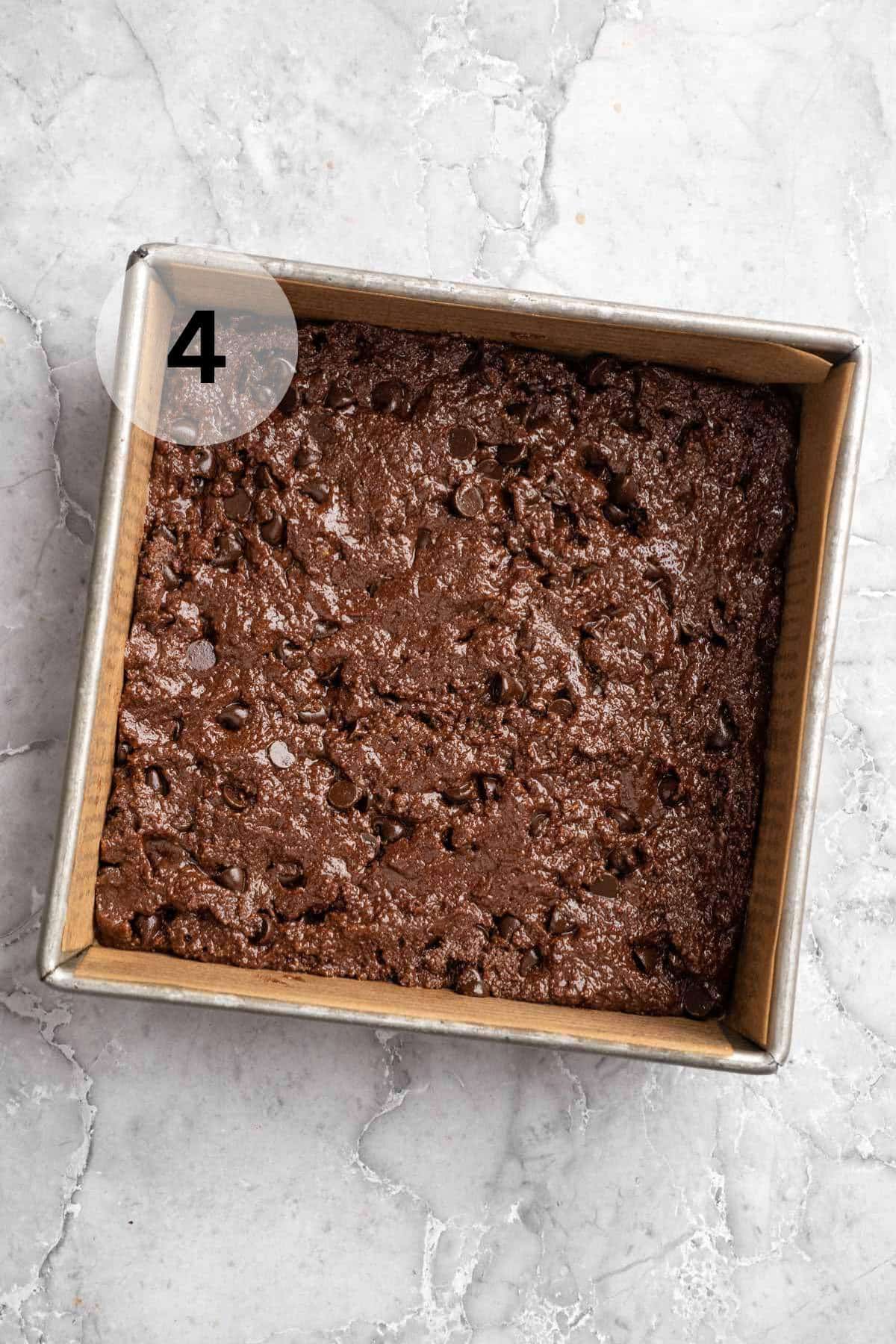 Brownie batter in a square pan.