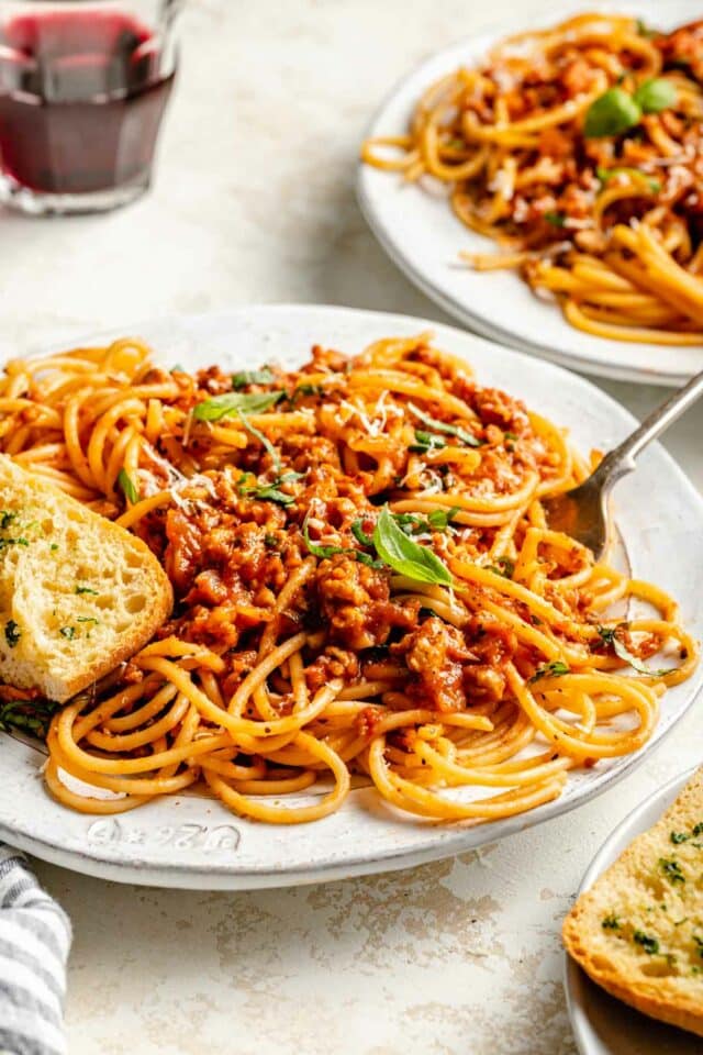 Turkey Bolognese with spaghetti on a white plate.
