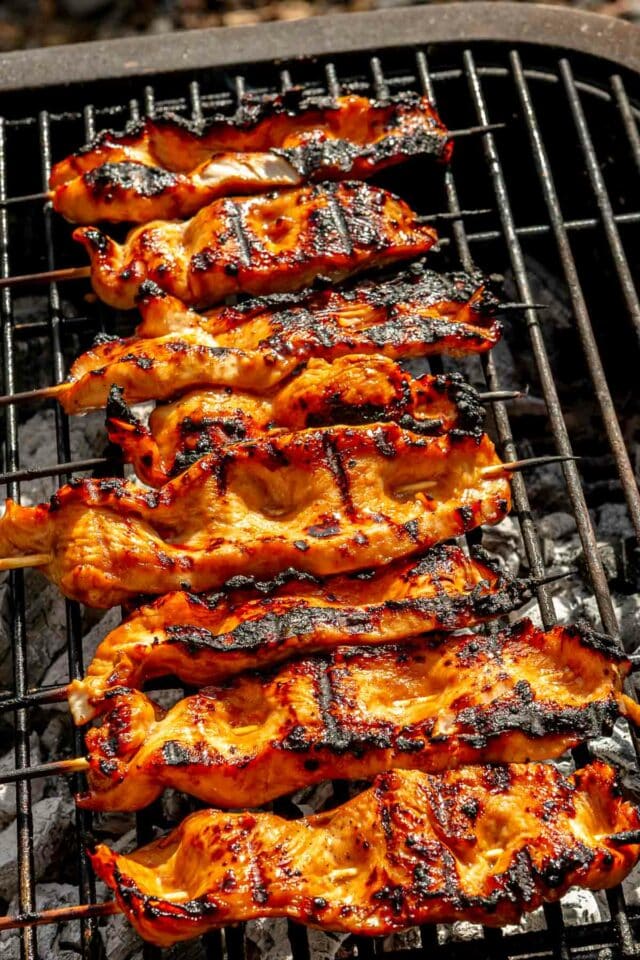 Chicken skewers with grill marks on a grill. 