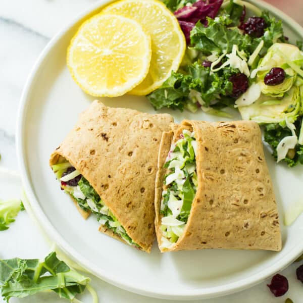 Take your sandwiches and wraps up a notch with these fully loaded Sweet Kale Vegetable Salad Wraps! Packed with fresh vegetables, dried cranberries, roasted pumpkin seeds and a delicious poppyseed dressing, these low calorie, high flavor wraps are the perfect vegetarian and gluten-free lunch or dinner!