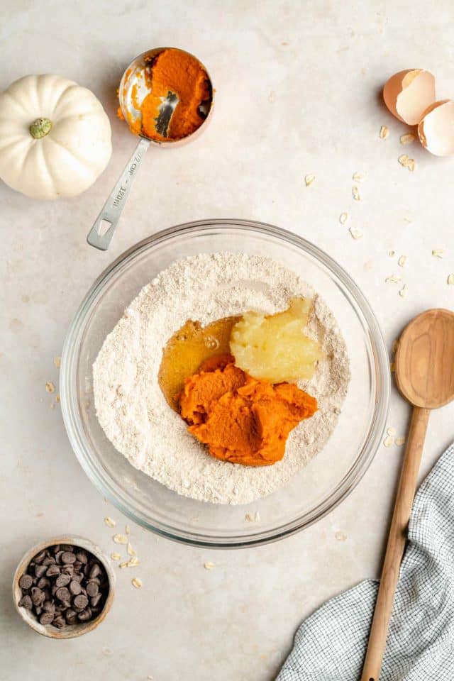 mixing ingredients for healthy pumpkin cookies in a large glass mixing bowl