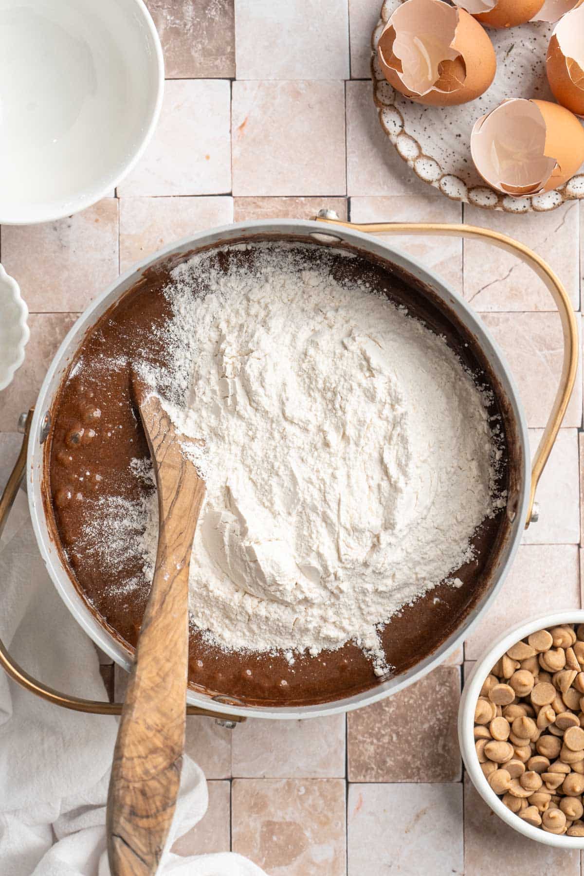 Using a wooden spoon to stir in flour.