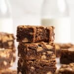 Three peanut butter brownies stacked and the top one has a bite taken out.