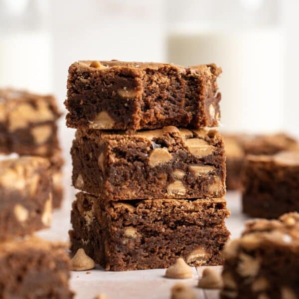 Three peanut butter brownies stacked and the top one has a bite taken out.