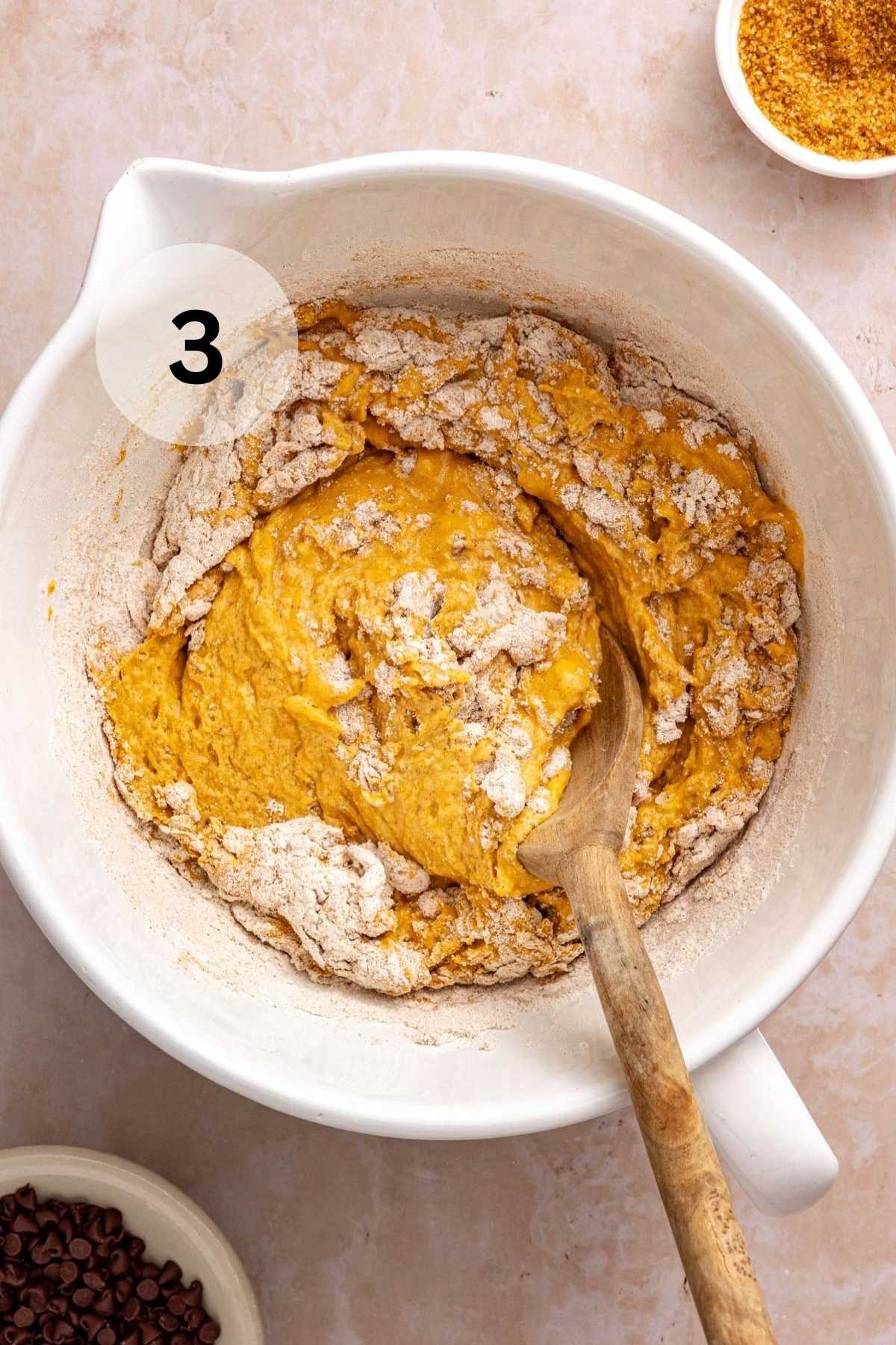 Combining wet and dry ingredients in a bowl.