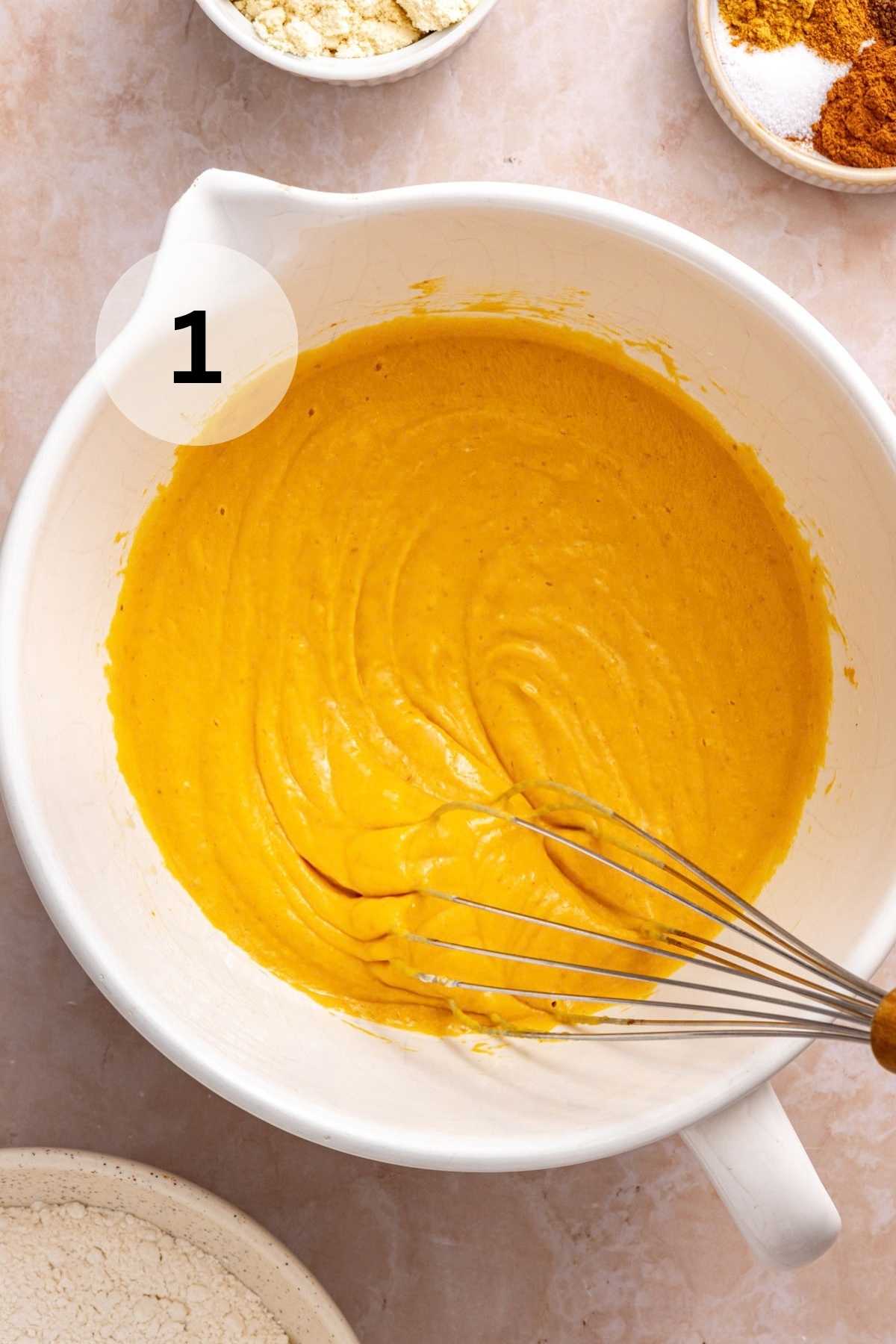 Whisking pumpkin puree, Greek yogurt, eggs, maple syrup, oil, and vanilla in a large bowl.