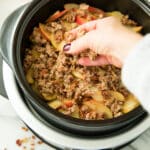 putting the crisp topping on a slow cooker apple crisp