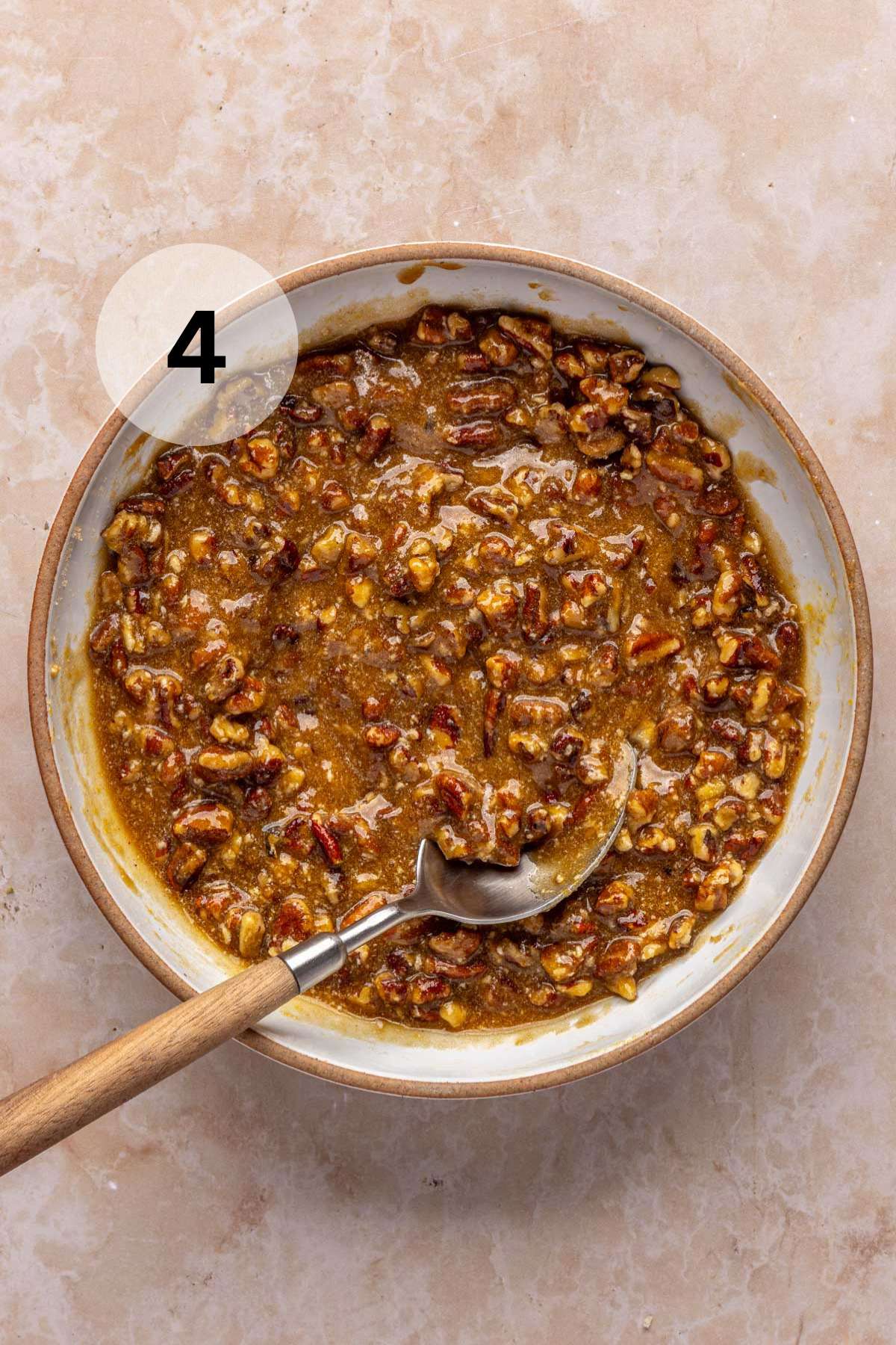 Pecan pie filling in a small bowl with a spoon.