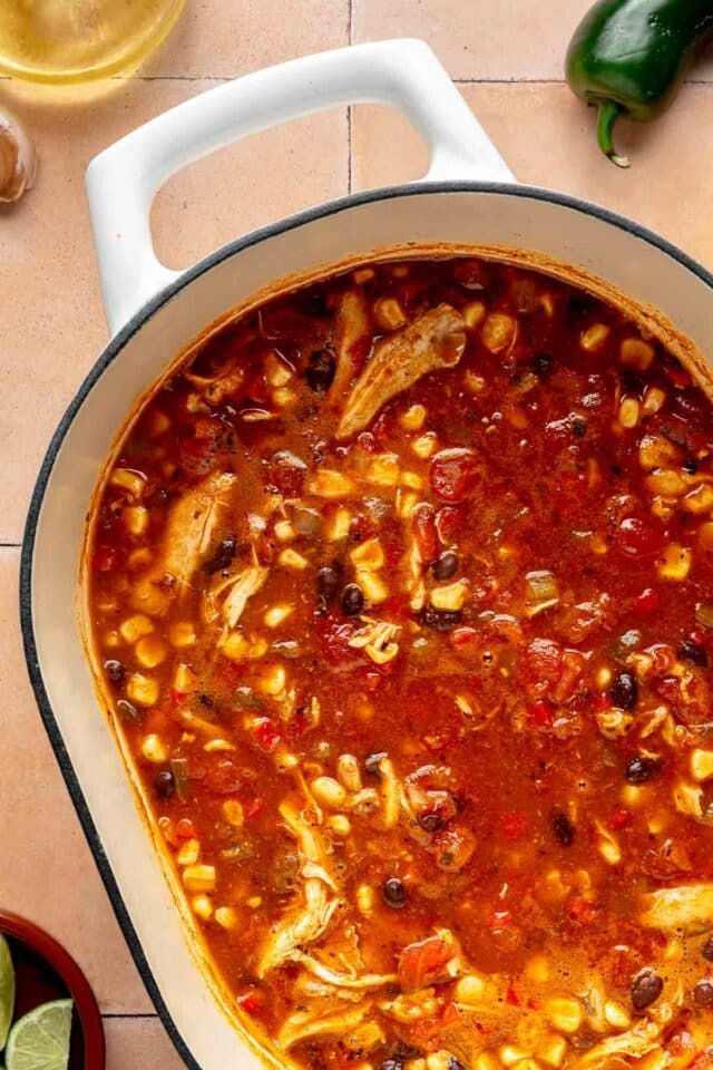 Chicken enchilada soup cooking in a large pot.