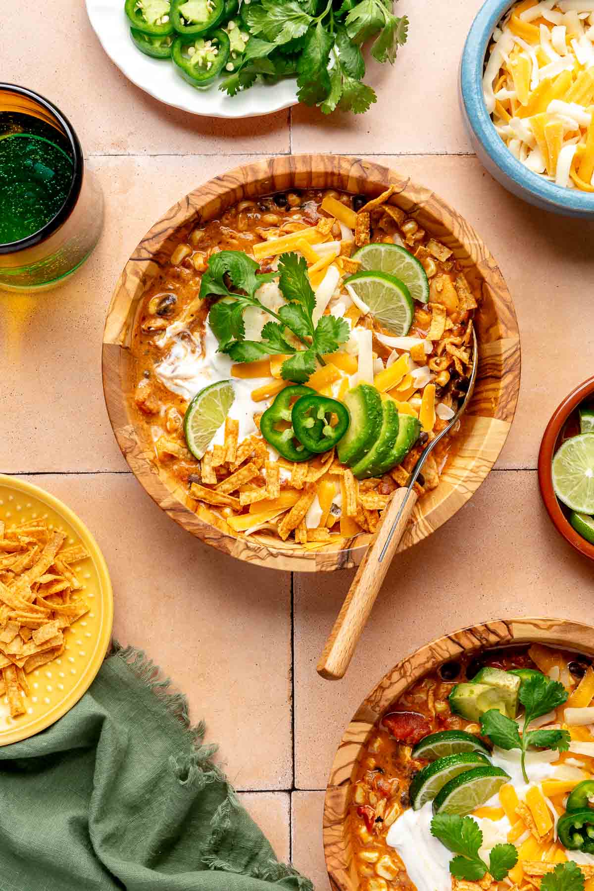 Chicken enchilada soup served with shredded cheese and fresh cilantro.