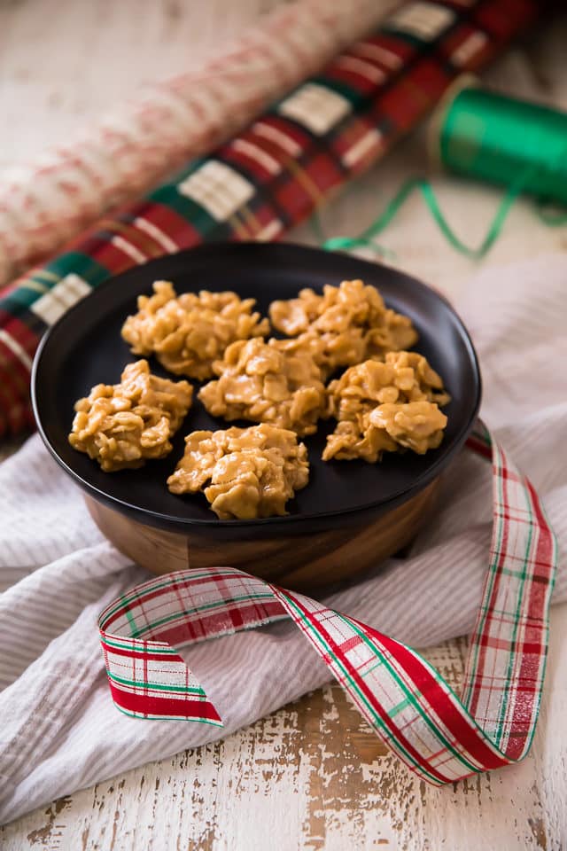 No Bake Peanut Butter Cookies on a black plate with Christmas wrapping paper and ribbon