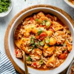 Jambalaya in a bowl garnished green onions.