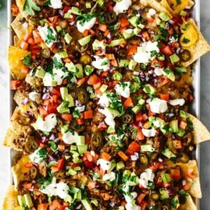 Nachos topped with avocado, sour cream and beef.