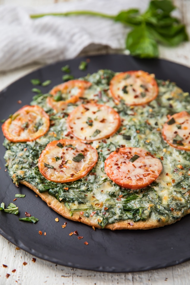 This Skinny Garlic Spinach White Pizza has everything you could ever want or enjoy in a pizza, without all the stuff your body doesn't love! This pizza is 100% clean eating friendly, with a sauce that is bursting with flavor! But the best part about this pizza!?! The crust!!!