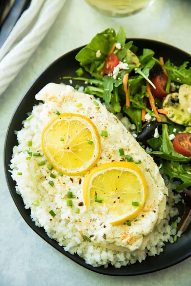 Garlic Parmesan Tilapia Over Cauliflower Rice is ready in less than 20 minutes! The tilapia cooks up light and flakey, and pairs wonderfully with cauliflower rice. It's one of my favorite ways to enjoy fish, and is so good, that even non-seafood lovers will be won over by this dish!