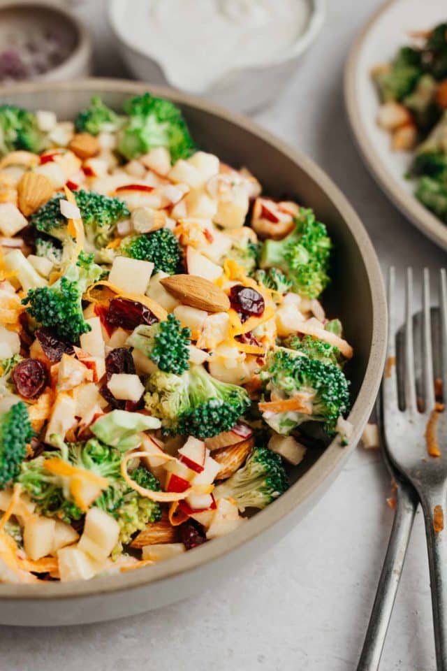 Broccoli salads with almonds and apples served in a bowl.