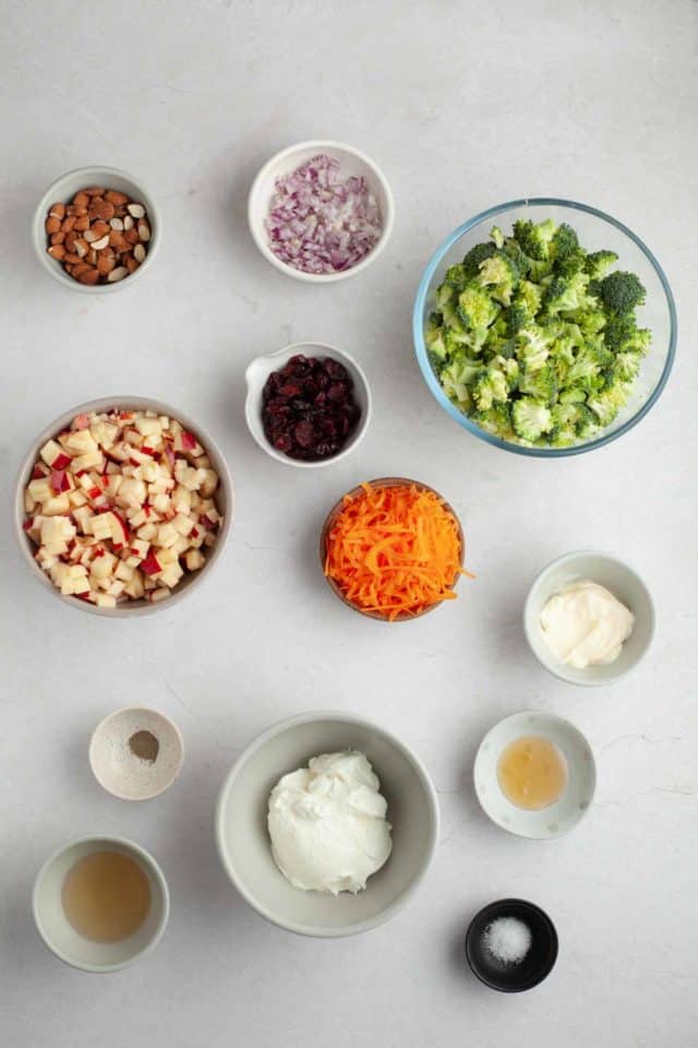 Ingredients for broccoli salad divided into small bowls.