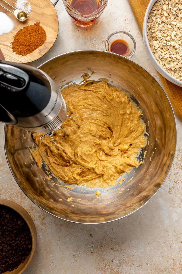 Using a mixer to mix mashed bananas with peanut butter and honey.